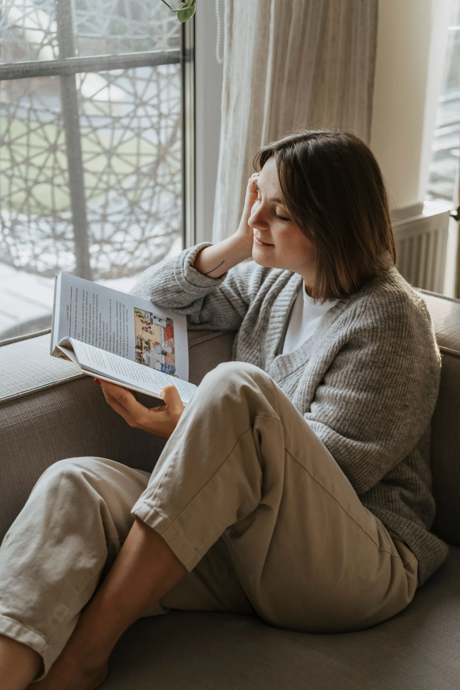 A woman reading by a sunny window